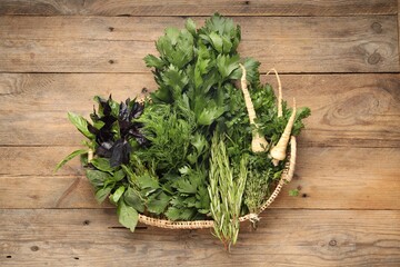 Different aromatic herbs in wicker basket, top view