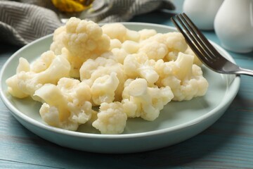 Tasty cooked cauliflower on light blue wooden table, closeup