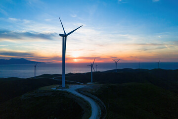 Wind turbine generator energy on colorful sunset, alternative energy sources with zero emission...