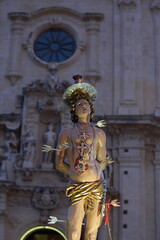 Saint Sebastian Pierced by Arrows on Processional Vara with Illuminated Baroque Church in the Background. Solemn Night Procession with the Statue of Saint Sebastian of Ferla.