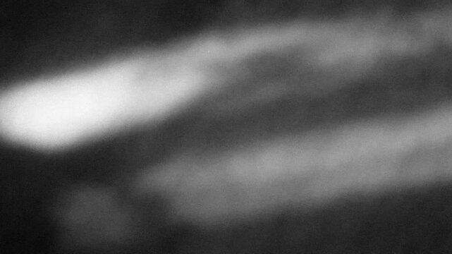 Grunge noise texture with light leaks background 4K stop motion video. Blurred backdrop loop footage with grainy effect. Monochrome black and white overlay video