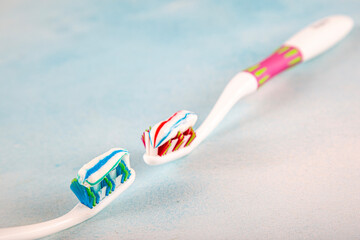 Toothbrush and toothpaste, squeezing toothpaste from tube onto toothbrush close-up. Daily oral care after meals concept.