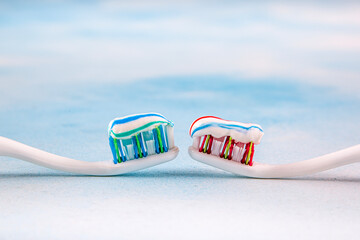Toothbrush and toothpaste, squeezing toothpaste from tube onto toothbrush close-up. Daily oral care after meals concept.