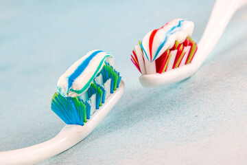 Toothbrush and toothpaste, squeezing toothpaste from tube onto toothbrush close-up. Daily oral care after meals concept.