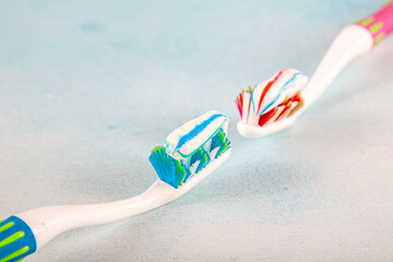 Toothbrush and toothpaste, squeezing toothpaste from tube onto toothbrush close-up. Daily oral care after meals concept.