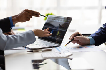 Businessman meeting with consultants discussing data analysis, charts and graphs in financial reports to plan investments and increase company profits. Strategy analysis and business planning meeting.