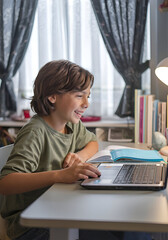 Child homeschooling in front of computer at a desk