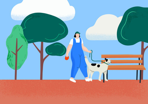 A girl in a green cap walking a dog in the park