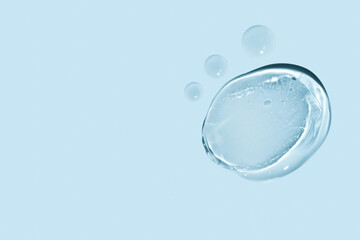 composition of smears of transparent gel and drops of liquid on a blue background.