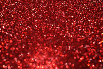 Red glitter bokeh background with sparkling light, abstract defocused texture. Holiday lights.