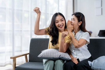 Two women are sitting on a couch