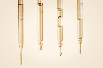 Fototapeta premium Set of Cosmetic pipettes with yellow liquid dripping. On a yellow background. Natural cosmetics, gold, acids, extract, serum, serum.