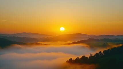 Obraz premium Serene Sunrise over Foggy Rolling Hills