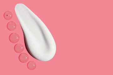 smear of transparent gel and cream on pink background with empty space.