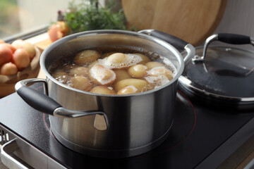 Boiling potatoes in pot on stove in kitchen
