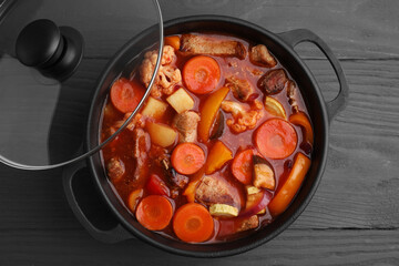 Tasty homemade stew with vegetables on grey wooden table, top view