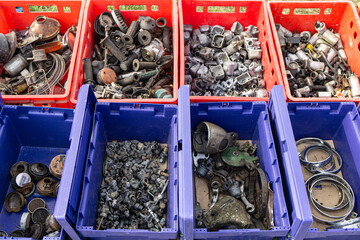 In the red and blue plastic containers, there are metal parts.