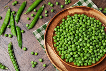 Fresh green peas and pods on wooden table, flat lay
