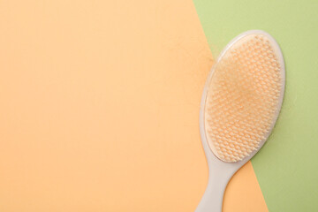 One brush with lost hair on color background, top view. Space for text