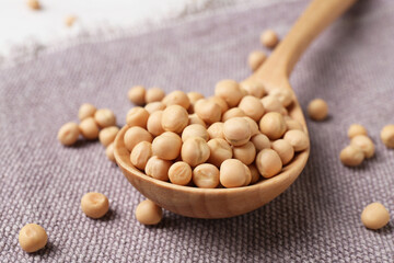 Spoon with dried peas on cloth, closeup
