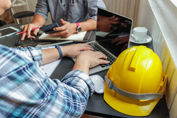 Fototapeta premium Hard yellow plastic helmets or helmets that are placed on the workbench of the engineering team for the safety of the work site. A safety helmet is a basic safety equipment for workers.