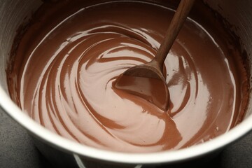 Chocolate dough and spoon in bowl, closeup
