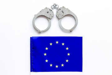Metal handcuffs for criminals with EU flag. Europe criminal law and justice concept