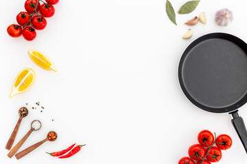 Cooking concept - empty frying pan with spices on the kitchen desk top