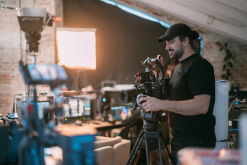 Director of photography with a camera in his hands on the set. Professional videographer at work on...