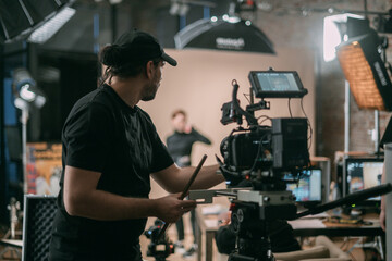 Director of photography with a camera in his hands on the set. Professional videographer at work on...