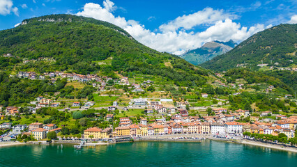 Fototapeta premium An aerial view of Domaso, a beautiful village nestled on the shores of Lake Como, Italy, captured by a drone. This charming destination is known for its picturesque lakeside scenery, quaint streets