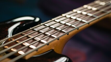 Fototapeta premium Close-up of a polished bass guitar fretboard with reflections