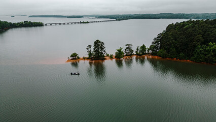 Drone shot of Bass fisherman fishing near bridge on raining day