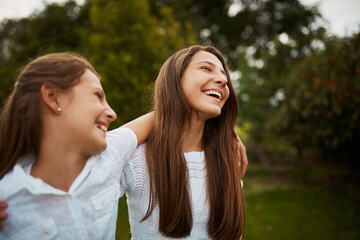 Fototapeta premium Girls, siblings and happy in park for bonding, love and support with trust, relationship and growth. Children, family and smile outdoor in nature for laugh, playing and childhood development with hug