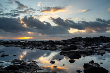 Sunset on the seashore with orange and blue strokes reflecting in the puddles. © AlbertoRodriguez