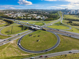 Rodovia Dom Pedro na altura da Avenida Mackenzie no bairro Vila Brandina. Visão aérea com tráfego na rodovia e rotatória.