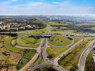 Rodovia Dom Pedro na altura da Avenida Mackenzie no bairro Vila Brandina. Visão aérea com tráfego na rodovia e rotatória.