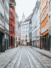 Fototapeta premium Colorful historic buildings line a narrow cobblestone street with tram tracks, showcasing classic European architecture and urban charm