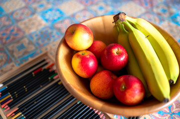 Bowl of apples and bananas on a colourful table setting