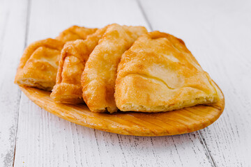 Freshly baked langos, savoury deep fried flat bread on wooden plate