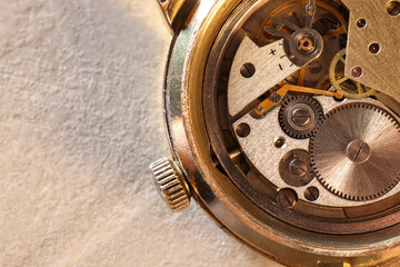 Mechanism of vintage wrist watch on beige table, top view. Space for text