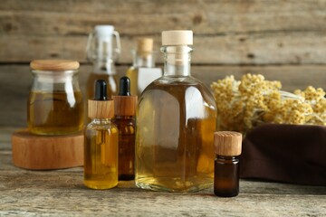 Different tinctures and helichrysum flowers on wooden table
