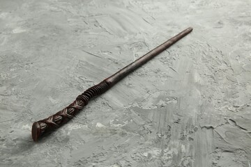 One old magic wand on grey textured table, closeup
