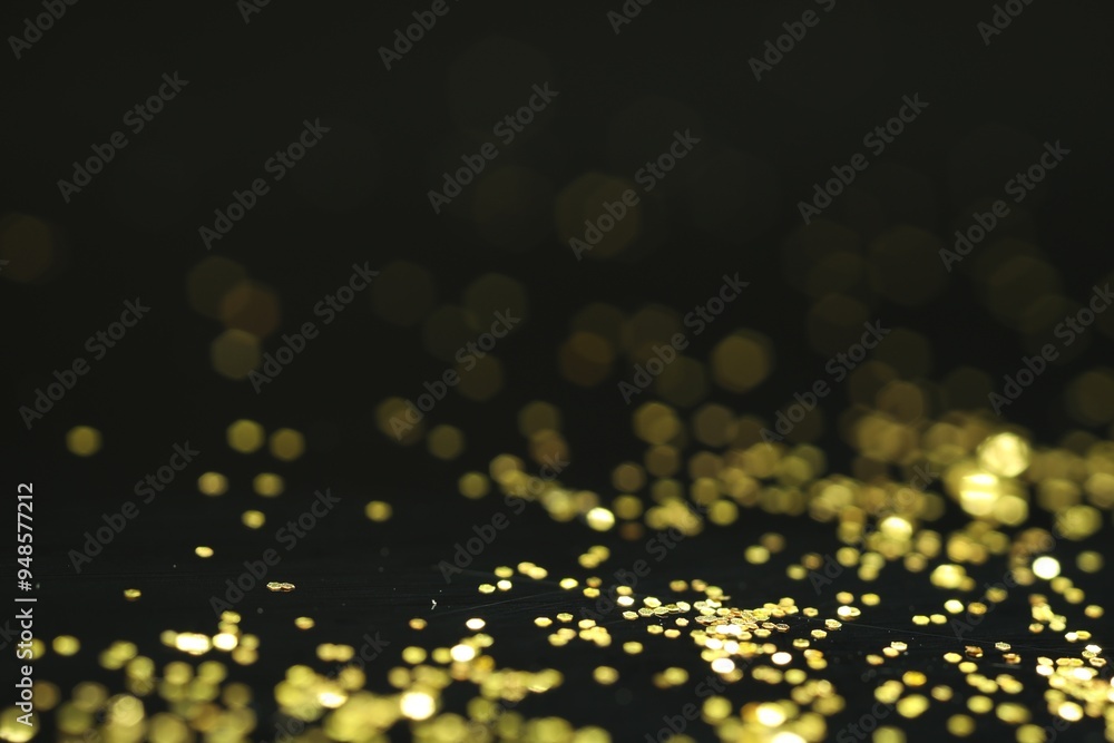 Wall mural Beautiful shiny golden glitter on black background, closeup