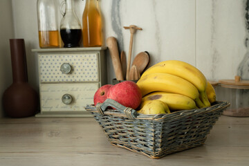 Basket with fresh fruits on table in kitchen