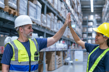 Senior team leader high fives with Asian female staff checking inventory and checking orders from customers, work completed in warehouse wholesale store.