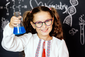 A young girl excitedly conducts a science experiment with a chemical flask. Ideal for highlighting educational activities and fostering a love for learning in children.