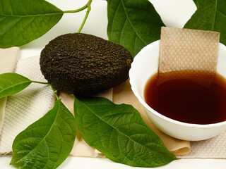 Bowl of avocado peel and pit decoction, avocado fruit, dried peel, branch with avocado leaves for...