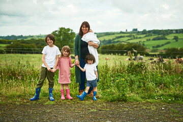 Portrait, family and kids with mother outdoor for love, care or holding hands together. Mom, children and siblings with baby in countryside for support, connection or people bonding on summer holiday