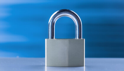 Naklejka premium Stainless steel padlock on metal surface. Blurred backdrop.